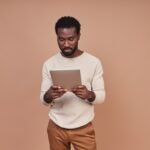 confident-young-african-man-casual-clothing-using-digital-tablet